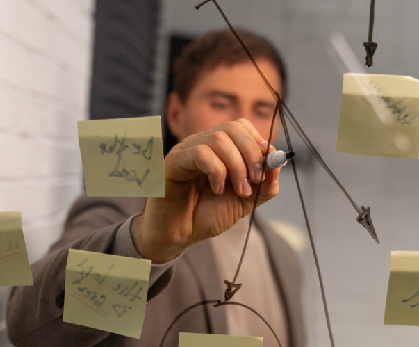 man draws arrows on mirror with marker